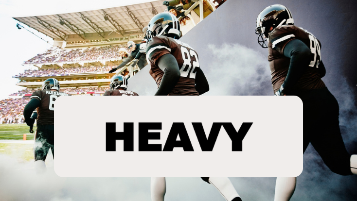 Football players enter a stadium through smoke beneath the Heavy logo.