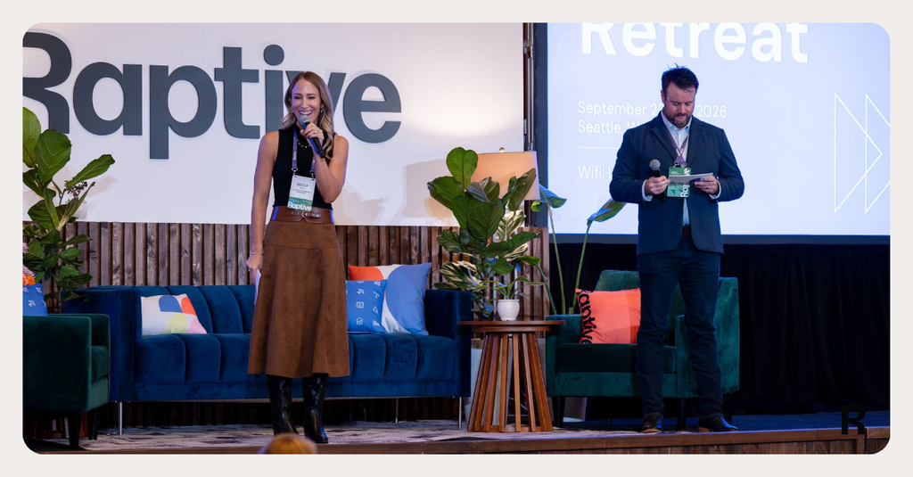 A Raptive Retreat host welcomes attendees onstage beneath the event screen and Raptive backdrop.